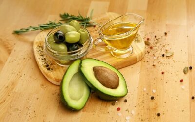 Food Ingredients. Olive Oil With Olives And Avocado On Table